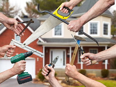 Several hands holding different tools used in building a fence